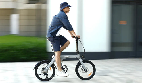 Mężczyzna jadący na rowerze elektrycznym Fiido D11 po drodze miejskiej.