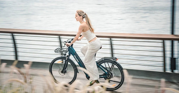 Kobieta jedzie po drodze na lekkim miejskim rowerze elektrycznym Fiido C11 Pro.