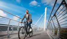 Mężczyzna jadący na rowerze elektrycznym Fiido C21 z wspomaganiem pedałowania po ścieżce rowerowej