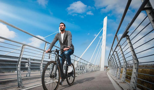Mężczyzna jadący na rowerze elektrycznym Fiido C21 z wspomaganiem pedałowania po ścieżce rowerowej