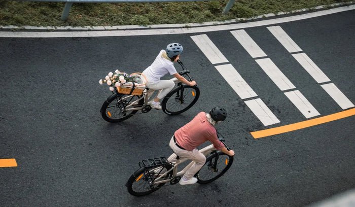 Obie osoby jadą na elektrycznych rowerach długodystansowych Fiido Nomads.