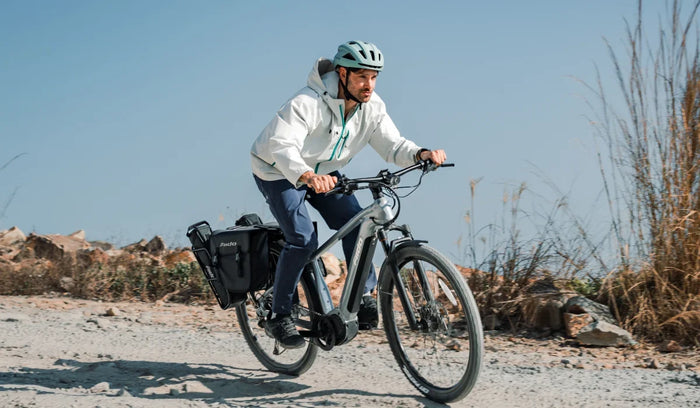 Turystyczny rower elektryczny Fiido Nomads Pro z mężczyzną jadącym w terenie