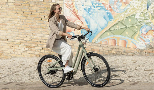 Kobieta jedzie ulicą na rowerze elektrycznym Fiido C700.