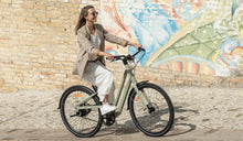 Kobieta jedzie ulicą na rowerze elektrycznym Fiido C700.