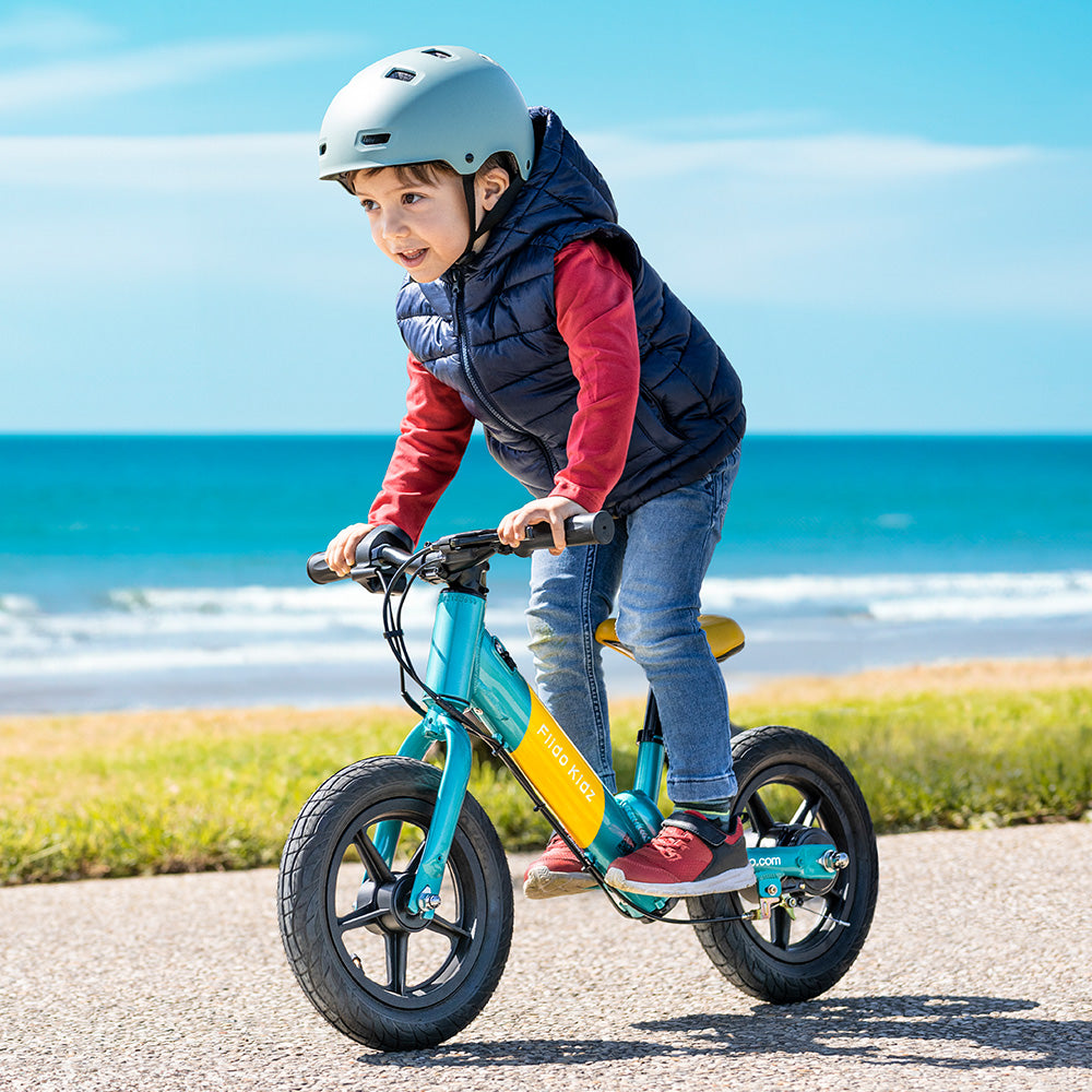 Dzieciak jeździ na elektrycznym rowerku biegowym Fiido Kidz